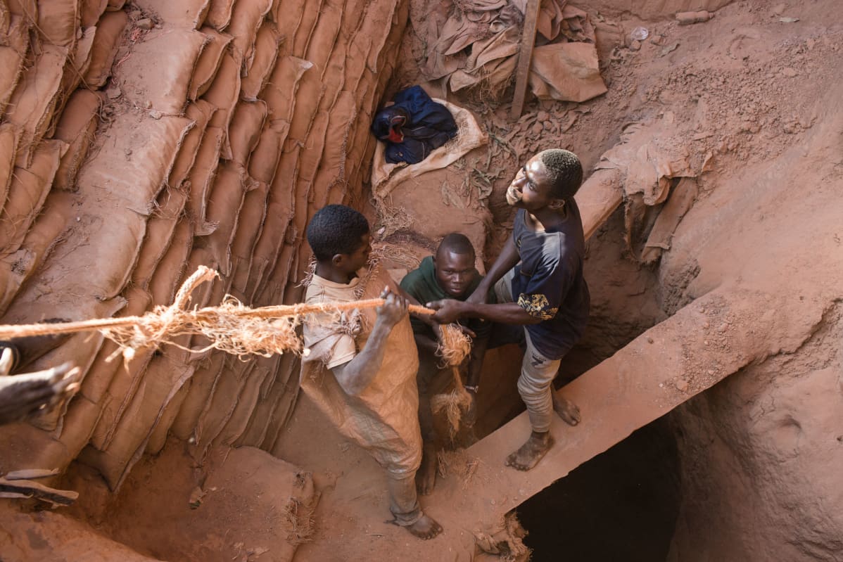 Miners pull up a bag of cobalt their colleague is digging underground inside the CDM (Congo DongFang Mining) Kasulo mine.