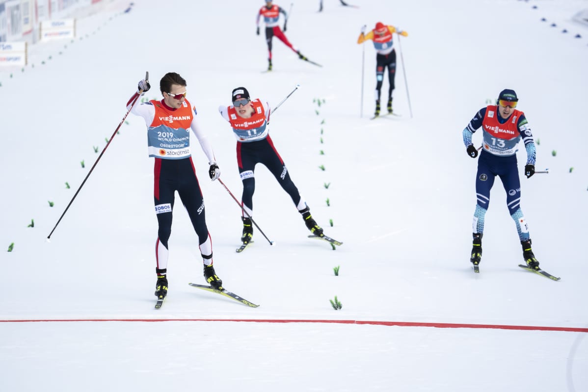 Norjan Jarl Magnus Riiber nostaa kätensä pystyyn voiton merkiksi. Suomen Ilkka Herola (oik.) sijoittuu hopealle ennen Riiberin maanmiestä Jens Lurås Oftebrota.