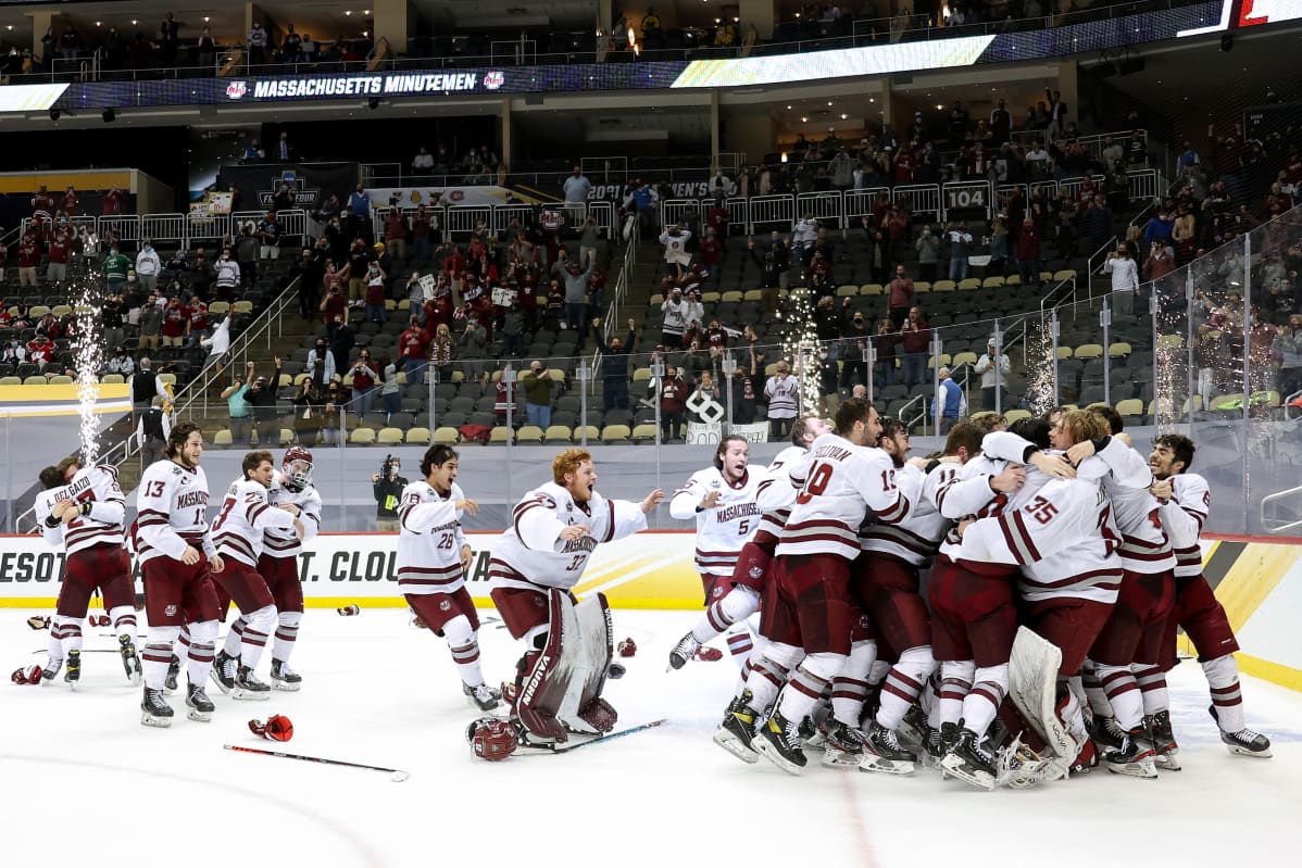 UMassin jääkiekkojoukkue halailee jäällä ja juhlii NCAA:n mestaruutta.