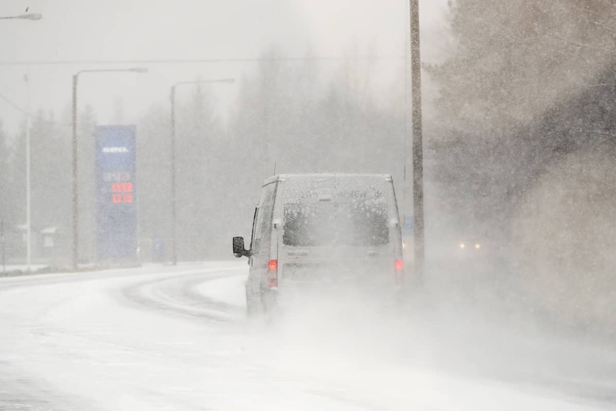 Auto ajaa lumipyryssä.