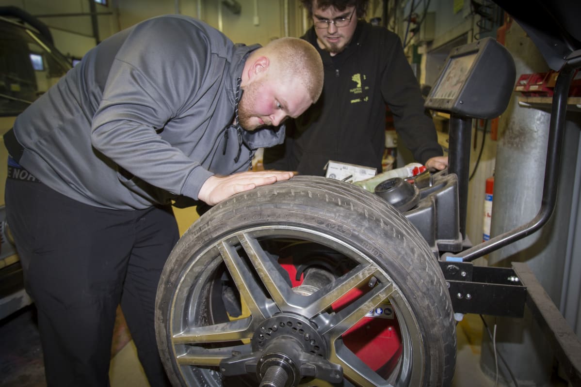 Konsta Vettenranta tasapainoittaa rengasta, Aivo Päri katselee.