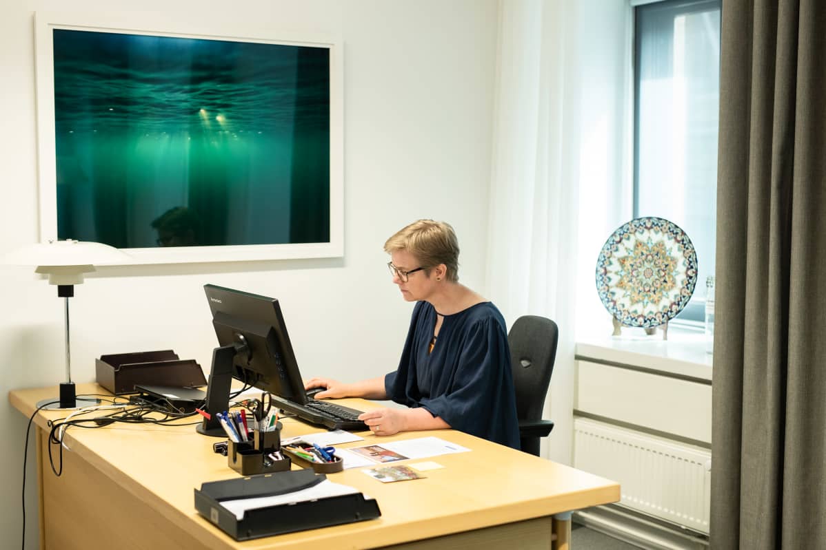 Krista Mikkonen työpöytänsä ääressä.