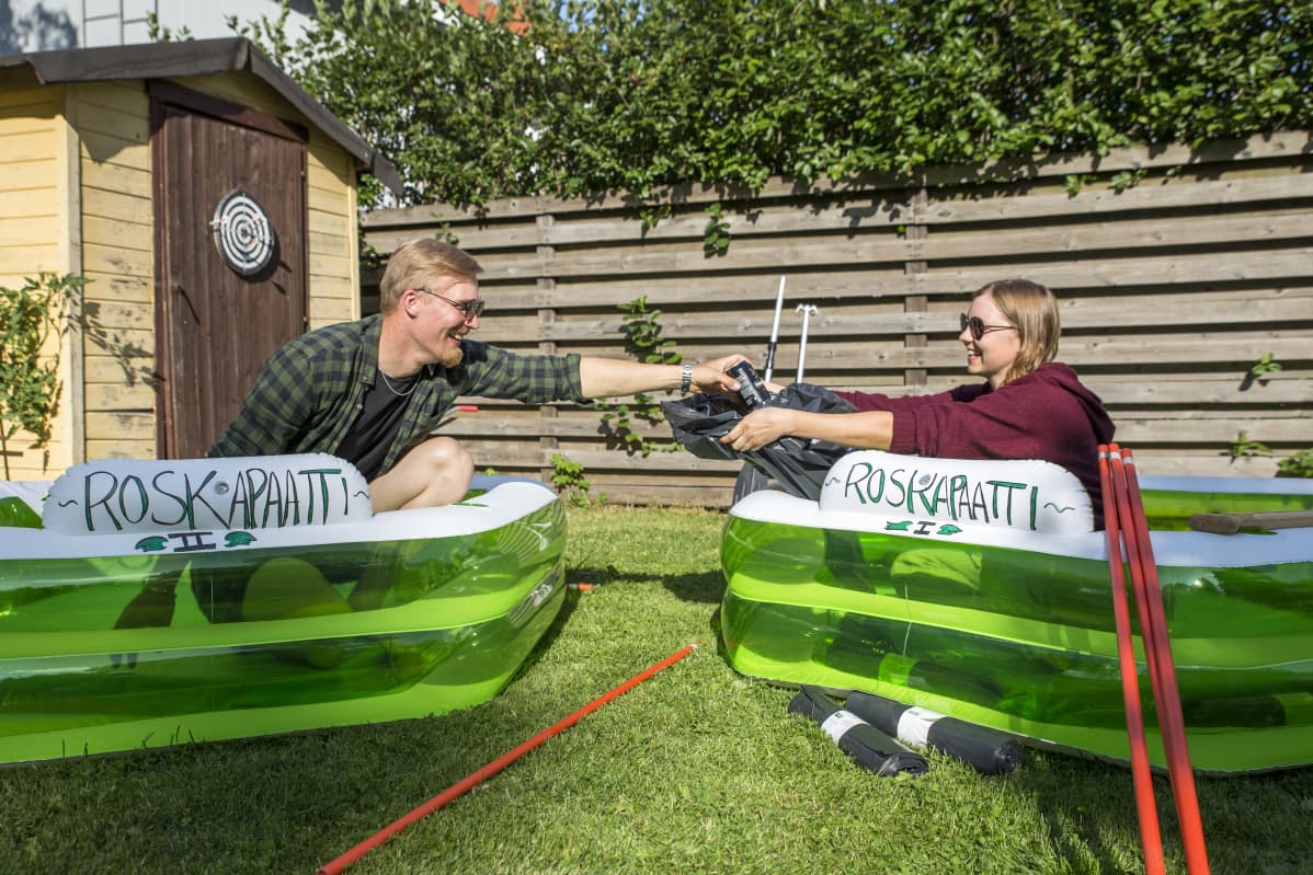 Pekka Kääriäinen ojentaa oluttölkkiä Jenna Kivivirralle joka ojentaa jätesäkkiä