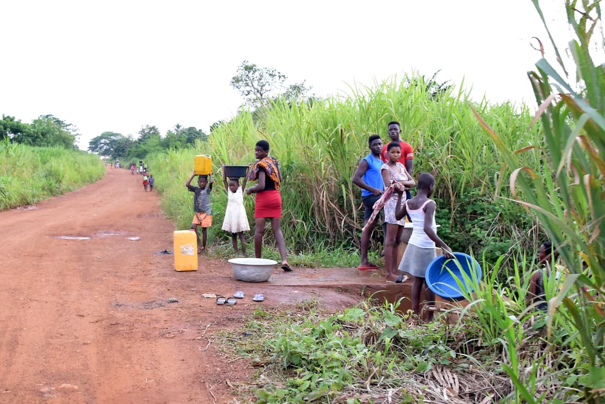 Afrikkalaisia naisia ja lapsia hakemassa vettä joesta
