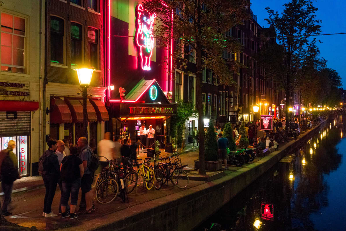 Red light district på natten. I bildens högermiljö ser man en av Amsterdams kanaler.