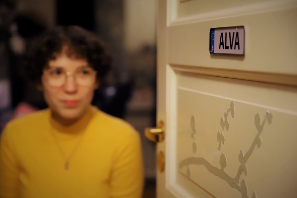 Alva Fontell katsoo huoneensa ovessa olevaan Alva-kylttiä.