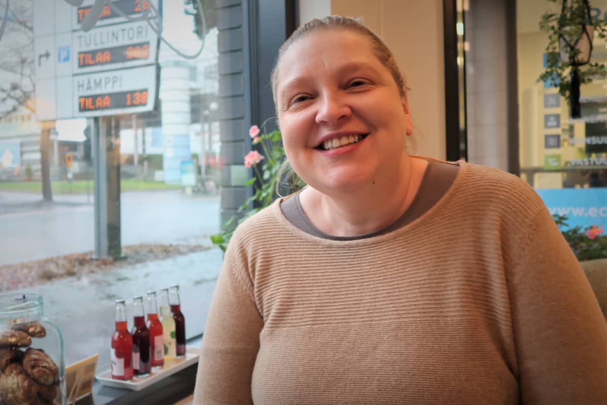 Sari Koskinen hymyilee kahvilan pöydässä