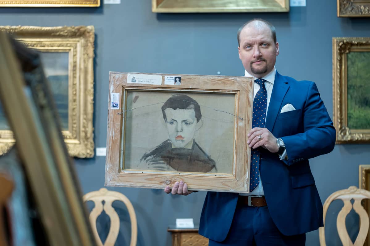 Hagelstam & Co -huutokauppatalon toimitusjohtaja Joachim Borgström kädessään Helene Schjerfbeckin taulu "Kukkiva omenapuu" sen kääntöpuolelta (Halkopojan harjoitelma), Helsinki, 5.3.2020.
