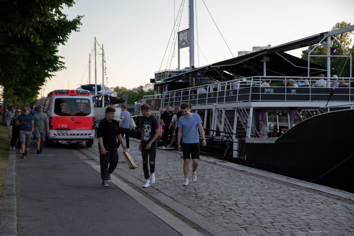 Ambulanssi ja juhlijoita Turun jokirannassa