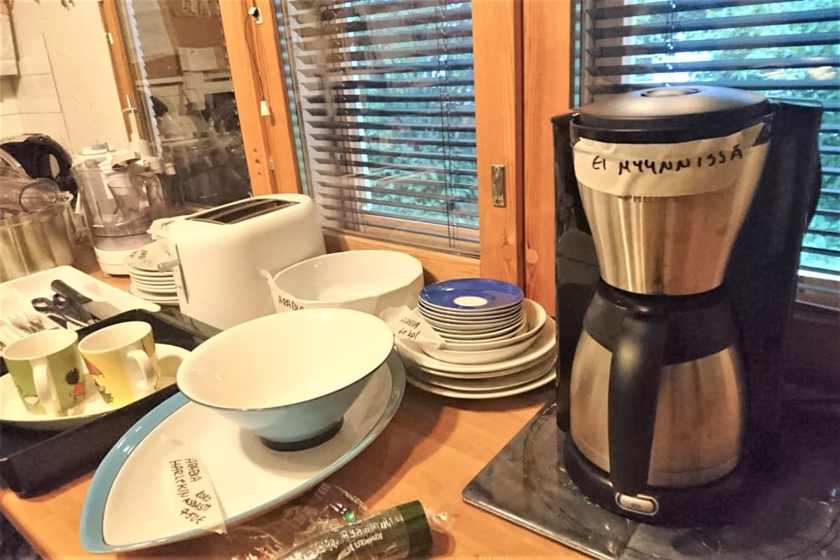 Astioita ja kahvinkeitin pöydällä. kahvinkeittimessa lappu "Ei myynnissä".