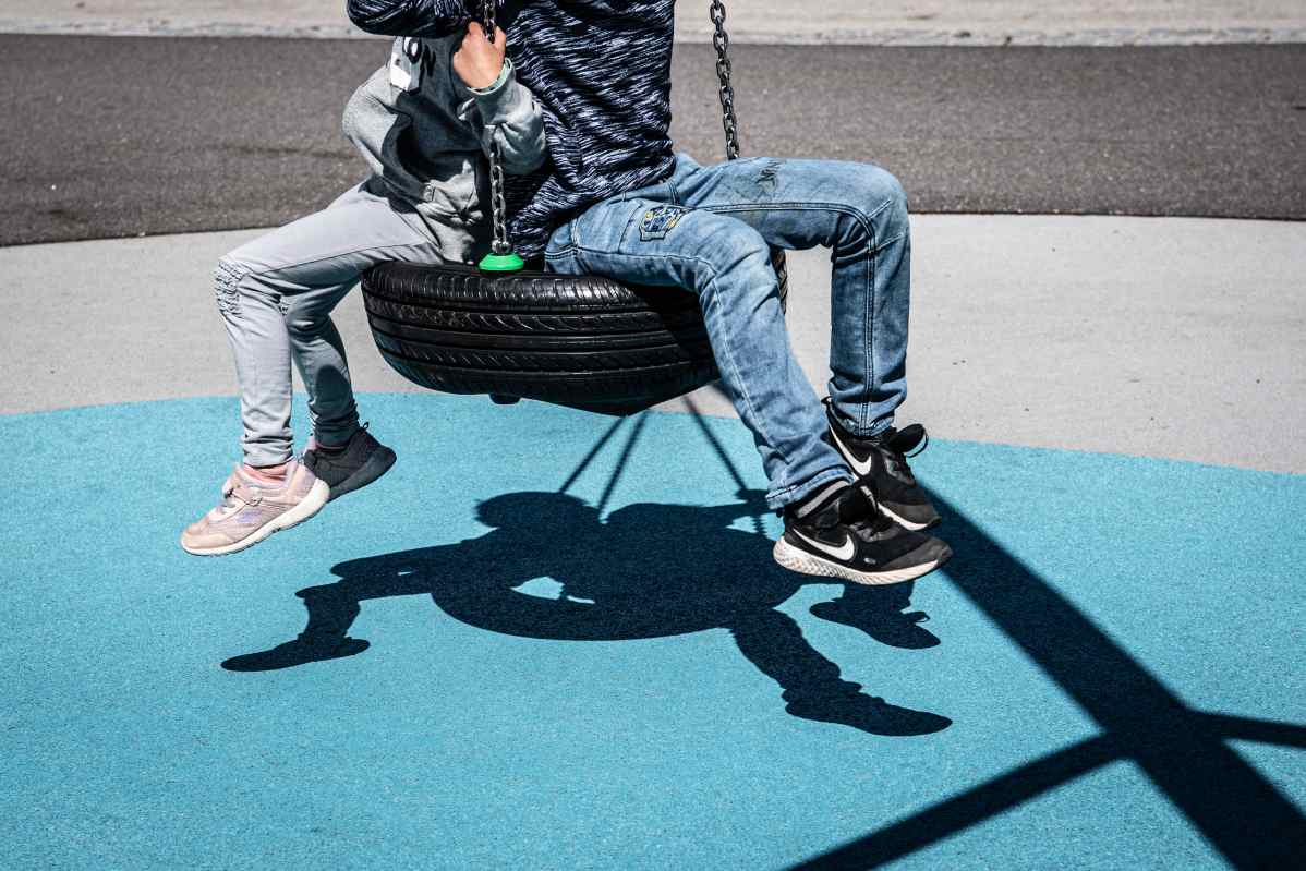 Anonyymit sisarukset keinussa.