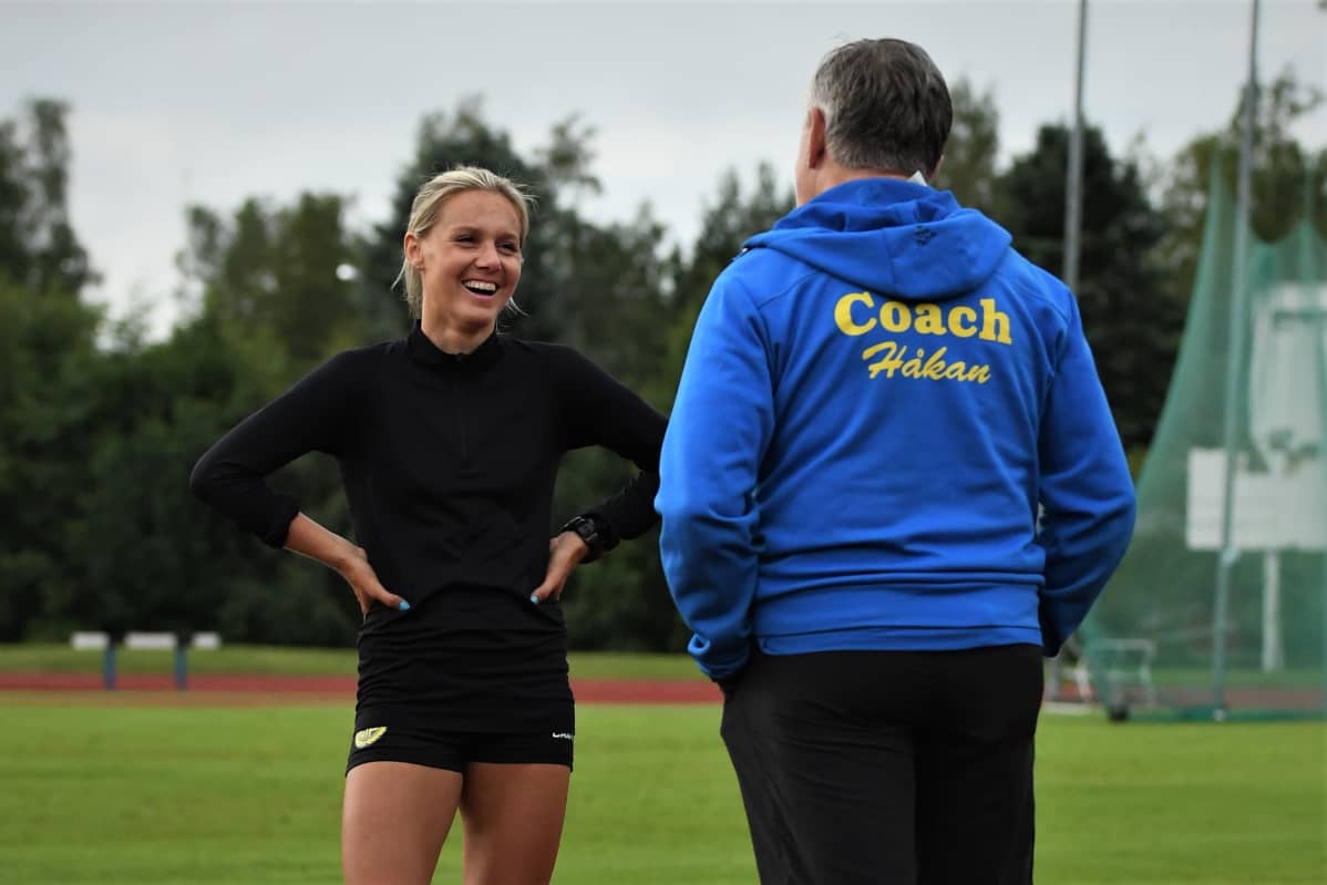 Nina Chydenius samtalar med tränaren Håkan Prest på sportplan.
