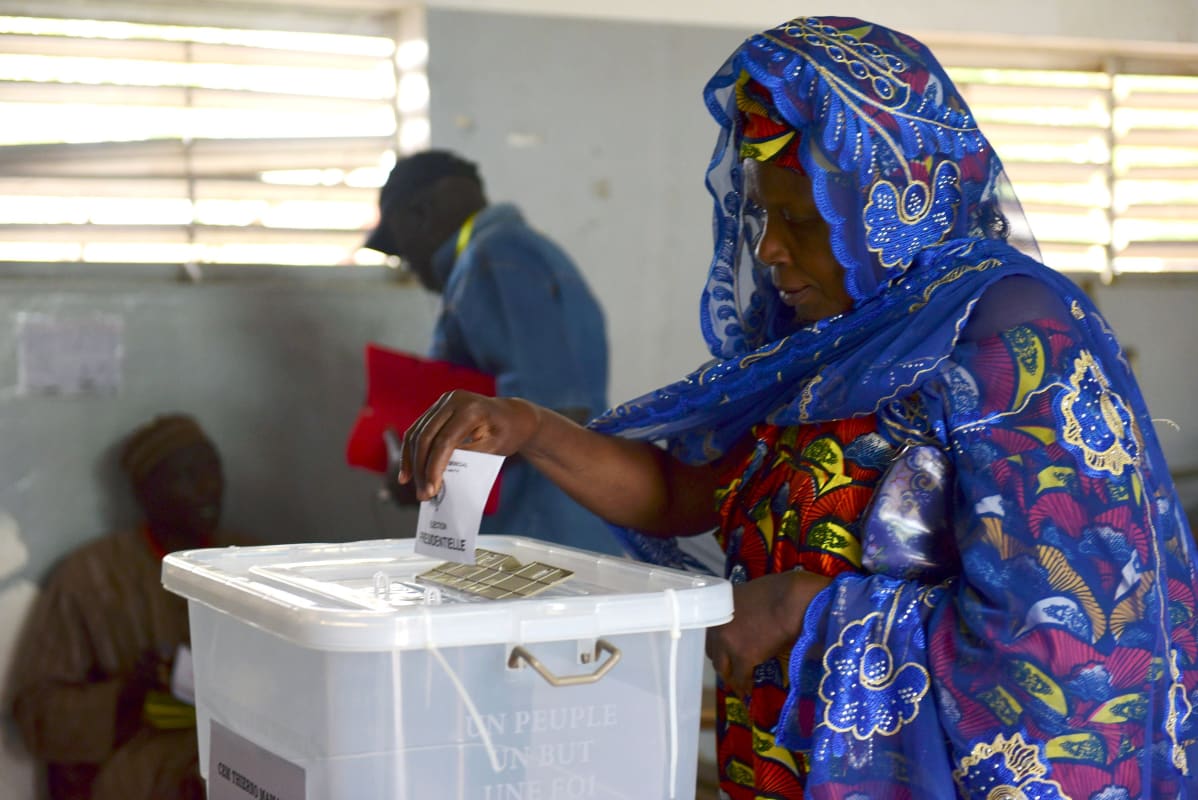 Nainen pudottaa äänestyslippua vaaliuurnaan Fatickissa Senegalissa.