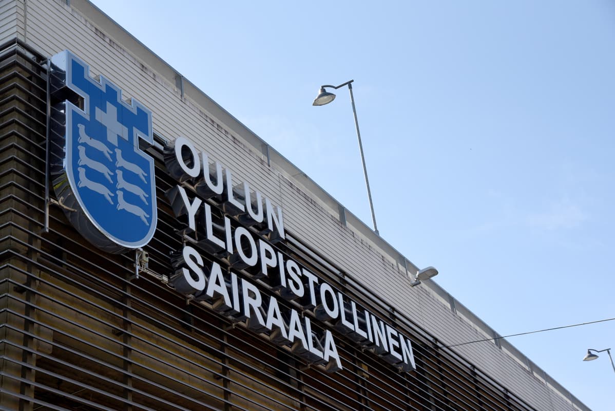 Oulun yliopistollisen sairaalan kyltti rakennuksen ulkoseinässä.