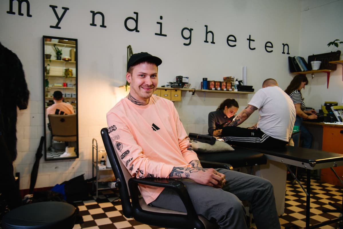 mies tuolissa tatuointistudiossa
