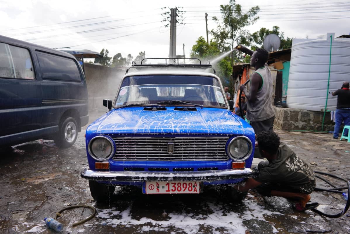 Mies pesee sinistä Ladaa Etiopian pääkaupungissa Addis Abebassa.