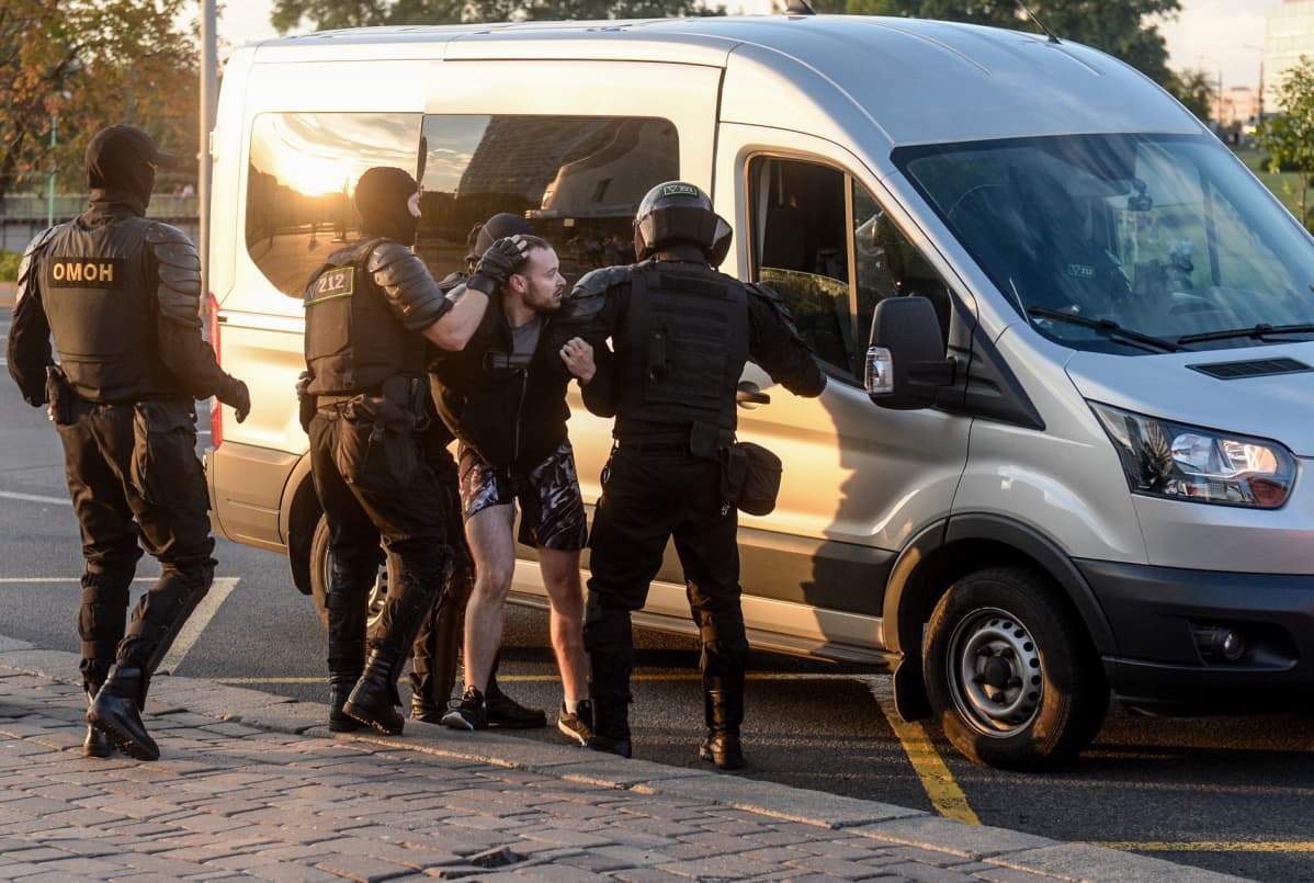 Poliisi vie mielenosoittajaa autoon
