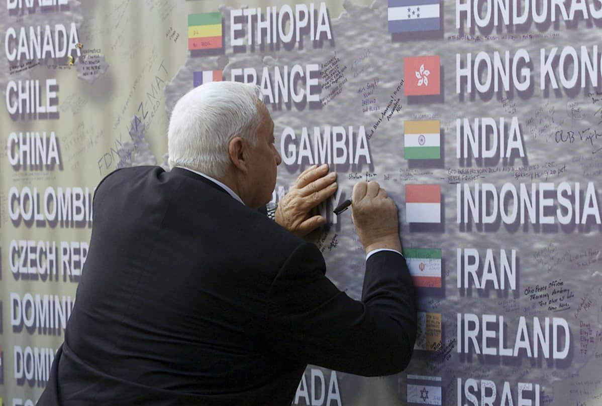 Israelin pääministeri Ariel Sharon kirjoittaa viestiään Saksan lipun perään WTC-iskun muistomerkillä New Yorkissa 30. marraskuuta 2001.