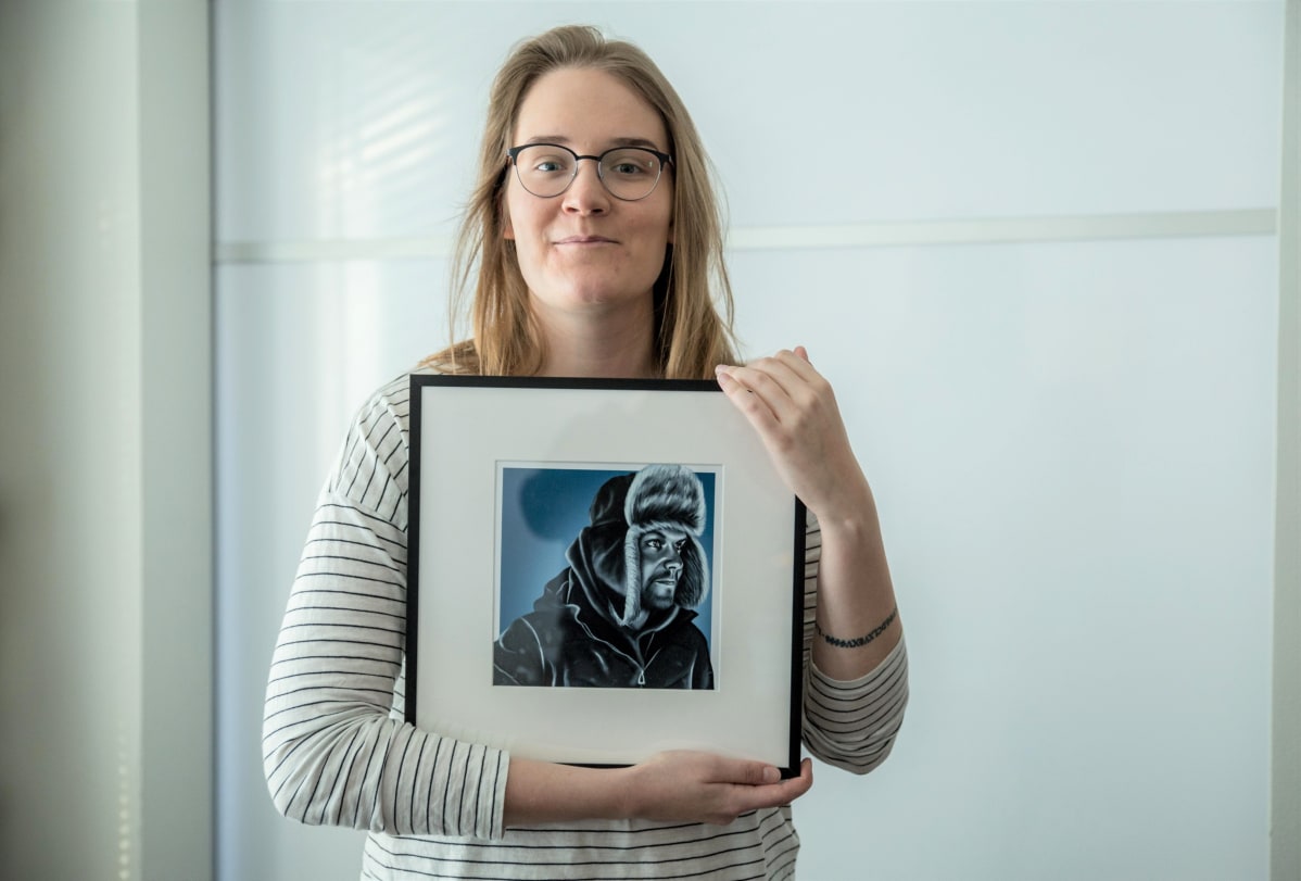 Nainen poseeraa kuvan kanssa