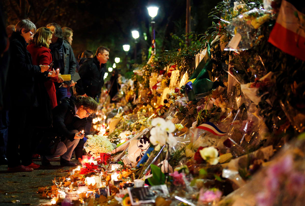 Ihmiset toivat kukkia ja kynttilöitä muistopaikalle lähelle Bataclan -konserttisalia, Pariisissa 20. marraskuuta.