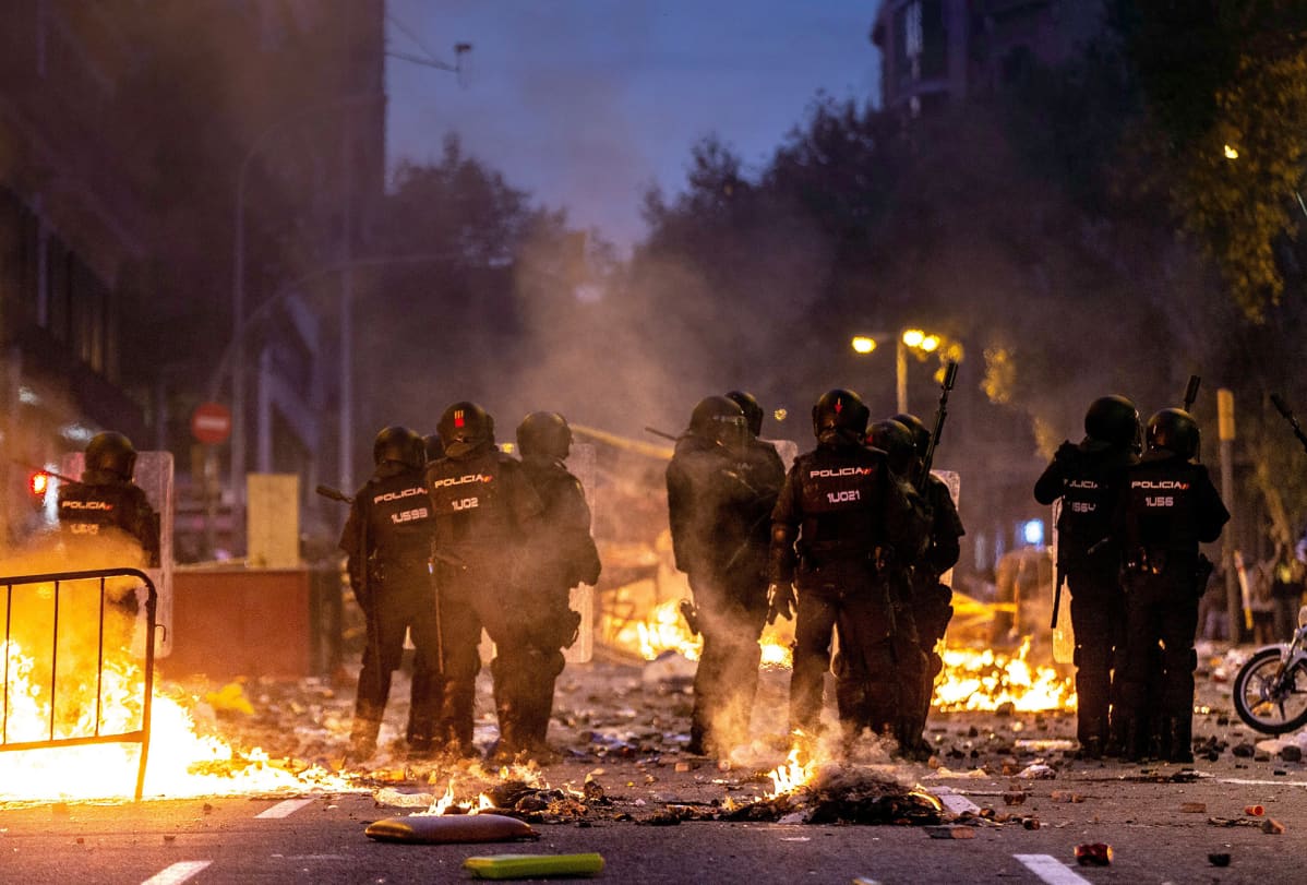 Mellakkapoliisit hajoittavat mielensoittajia.