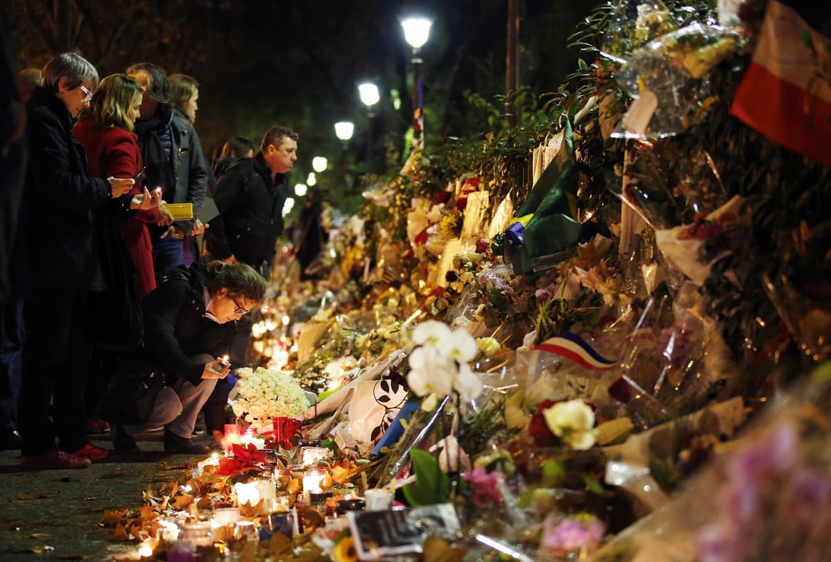 Ihmiset toivat kukkia ja kynttilöitä muistopaikalle lähelle Bataclan -konserttisalia, Pariisissa 20. marraskuuta.