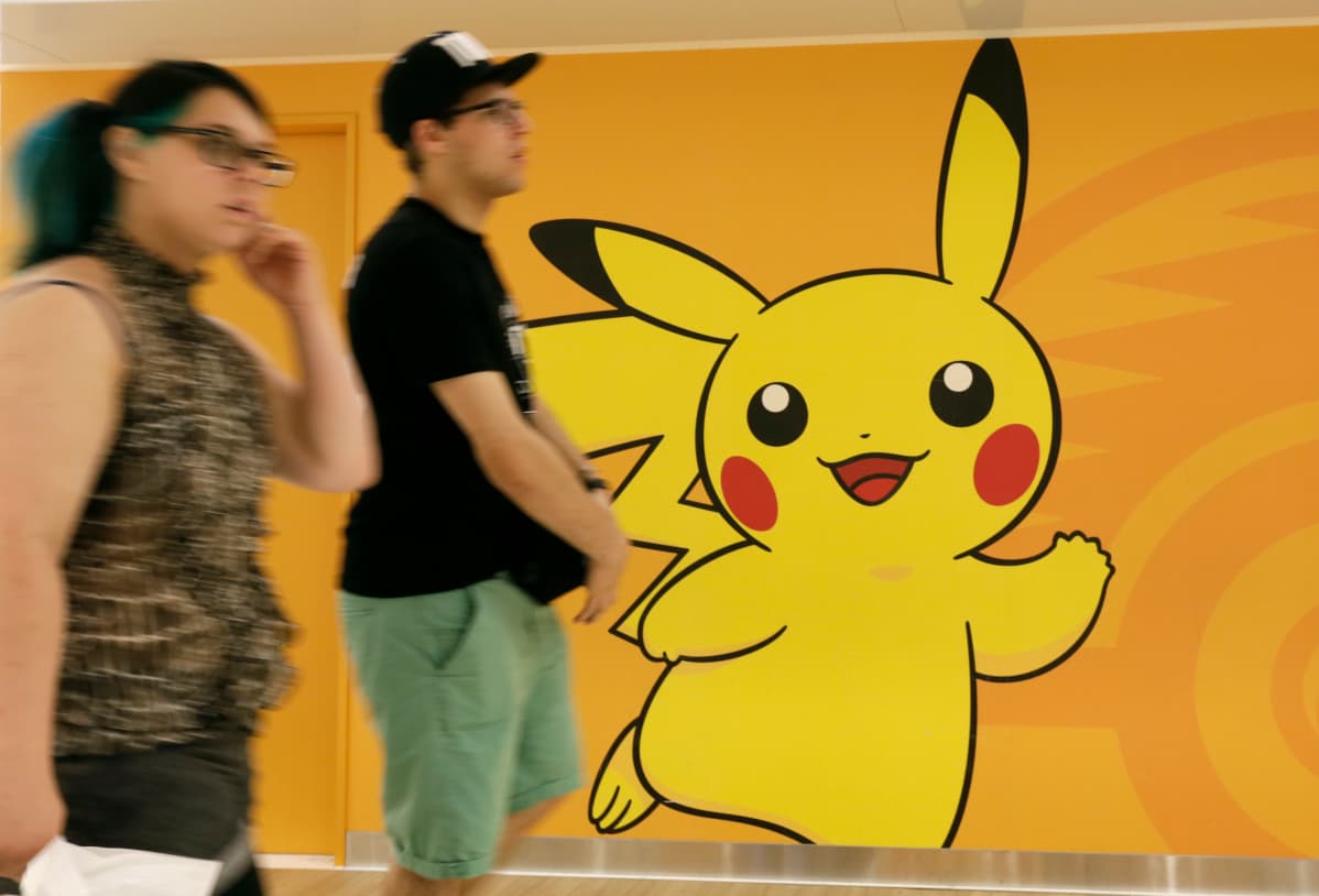 Turistit kävelevät seinään maalatun Pikachu-hahmon ohi Japanissa heinäkuussa 2016.