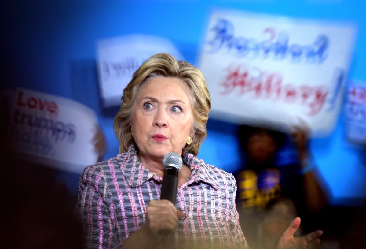 Hillary mikrofoni kädessä.