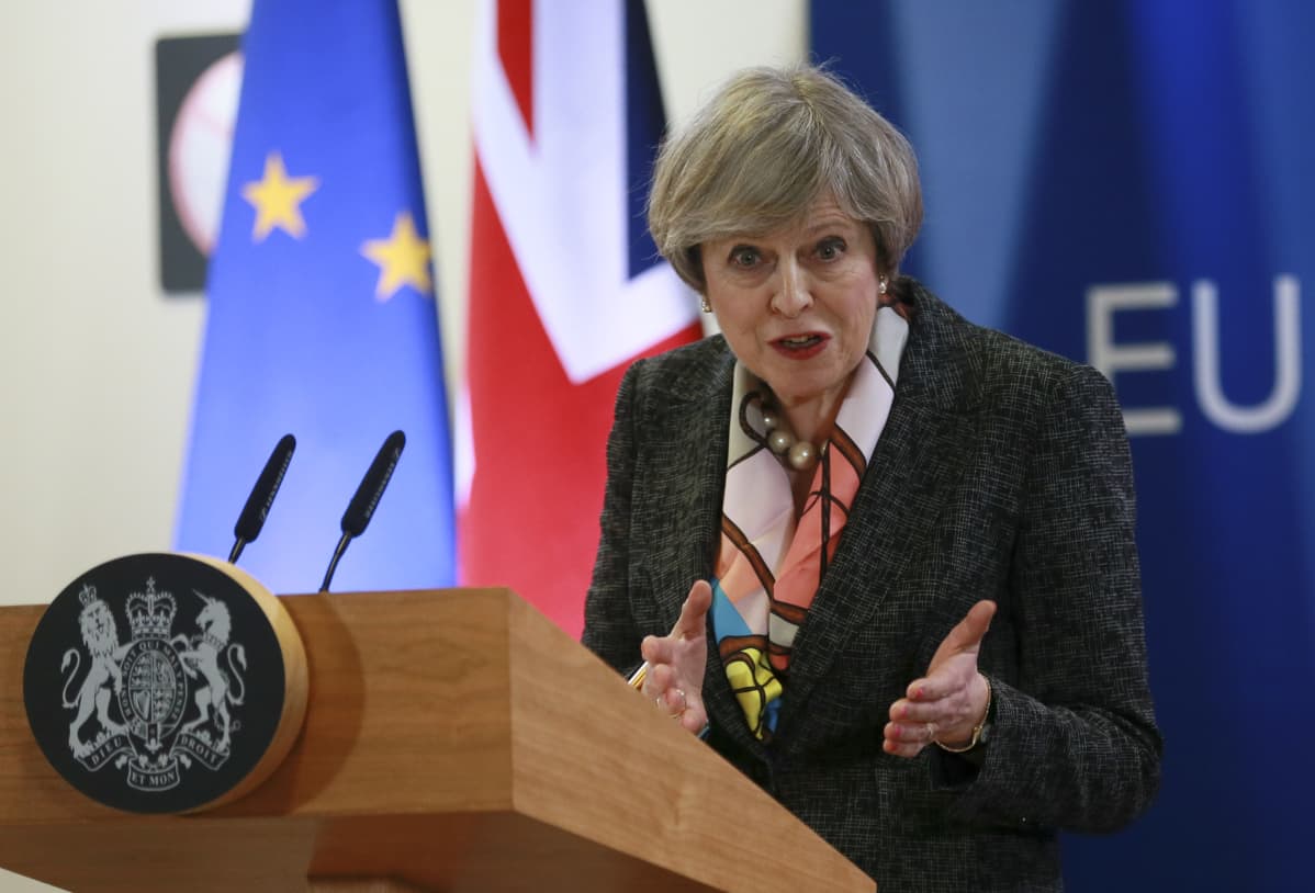 Britanian pääministeri Theresa May puhuu EU:n huippukokouksessa Brysselissä 09. maaliskuussa 2017. Taustalla EU:n ja Britannian liput.