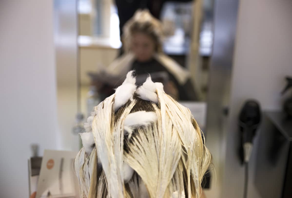 Asiakkaan hiuksia värjätään kampaamossa.