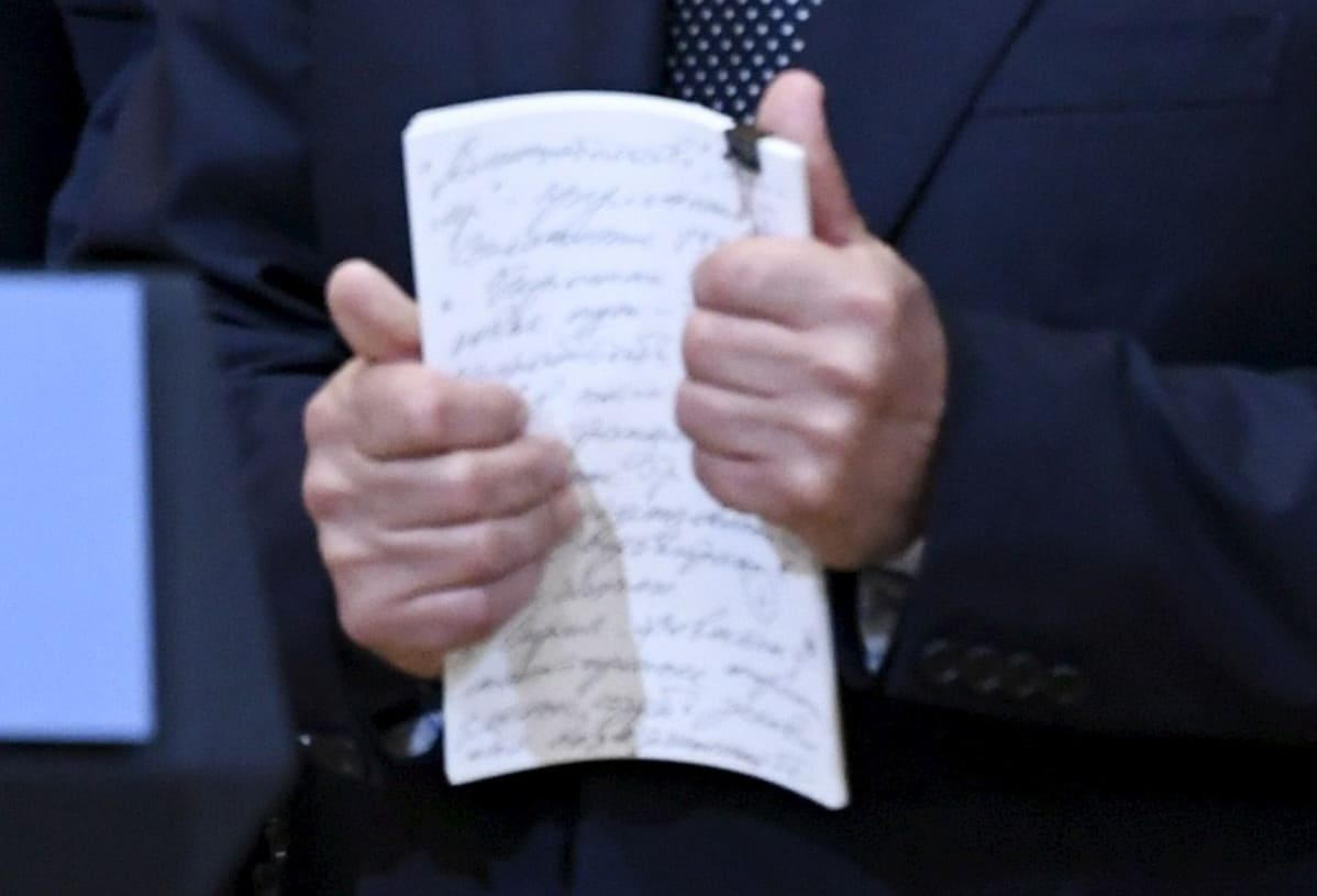 Muistiinpanot Putinin kädessä.