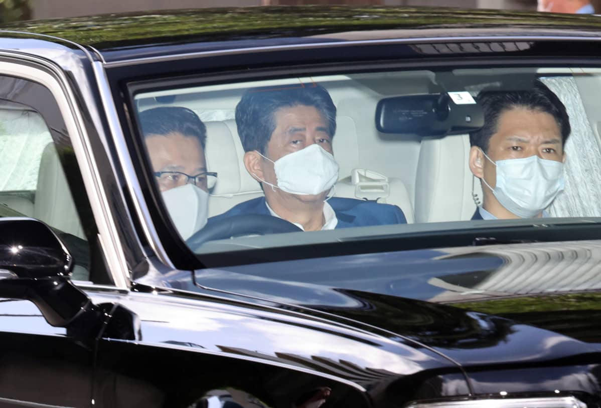 Shinzo Abe auton takapenkillä ikkunan läpi kuvattuna