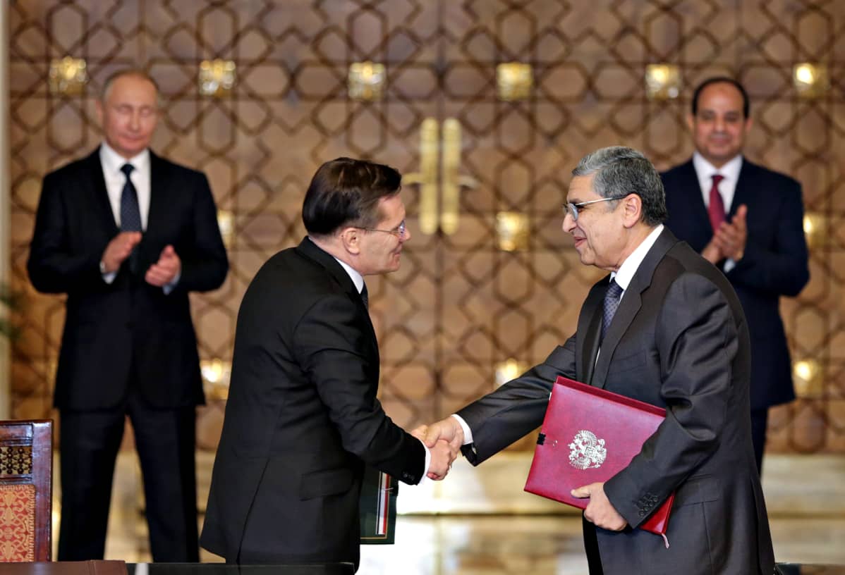Egyptin presidentti Abdel-Fattah El-Sissi (takana oikealla) ja Venäjän presidentti Vladimir Putin (takana vasemmalla) taputtavat, kun Egyptin sähkö- ja energiaministeri Mohamed Shaker (edessä oikealla) kättelee Rosatomin johtajan Alexey Likhachevin kanssa Kairossa 11. joulukuuta 2017.