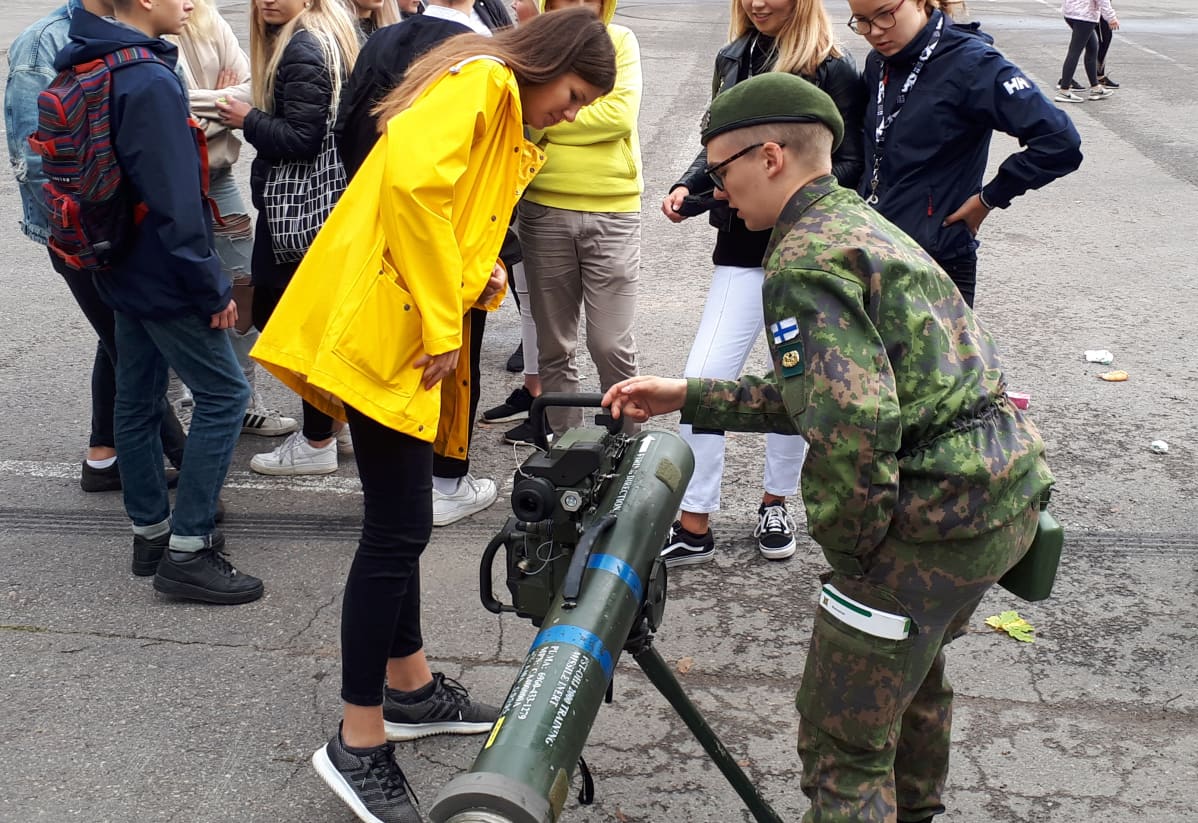 Aliupseerioppilas Joona Rissanen (oik.) näyttää Julia Riikoselle ja muille ysiluokkalaisille, kuinka panssarintorjuntaohjusta käytetään.