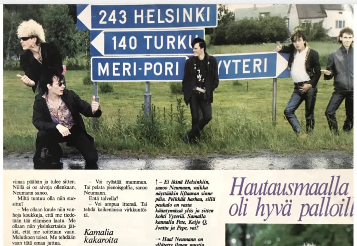 Dingon jäsenet tienviitan edessä