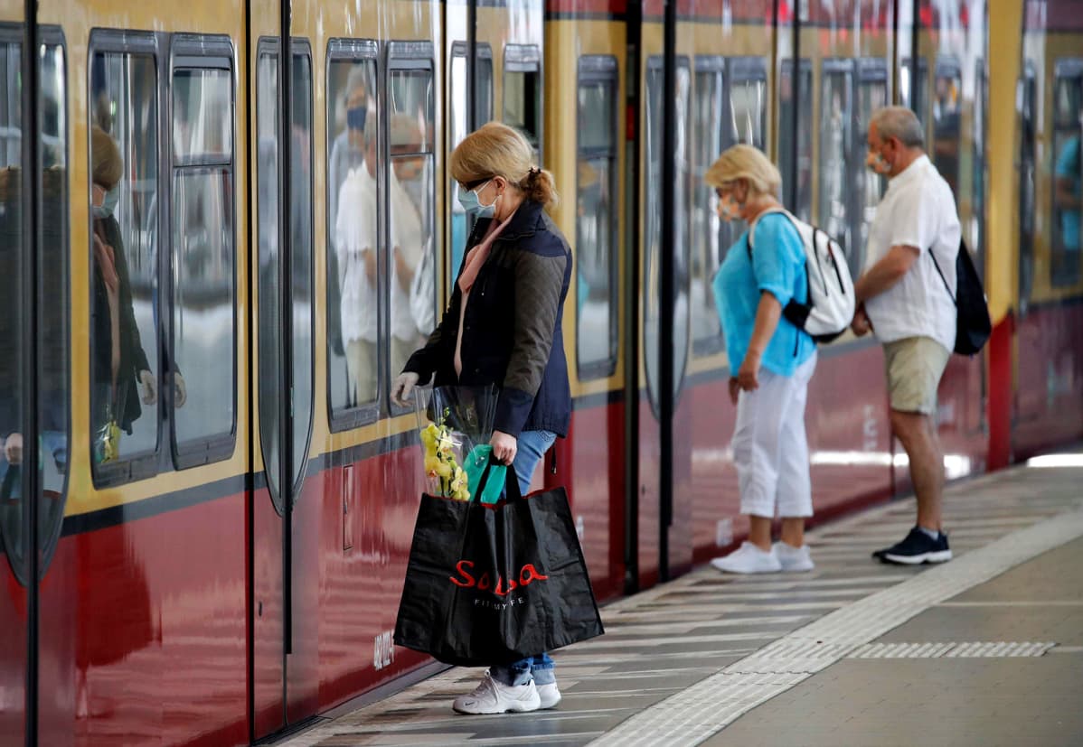 Kasvomaskeihin pukeutuneita matkustajia menossa paikallisjunaan Berliinissä. Maskit tulivat maanantaina pakolliseksi joukkoliikenteessä.