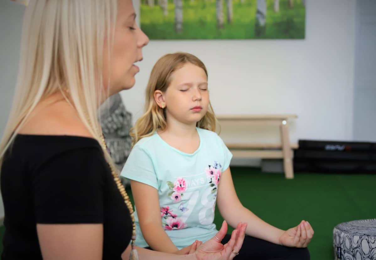 Lapsi toteuttaa mindfulness-harjoituksia yhdessä ohjaajan kanssa