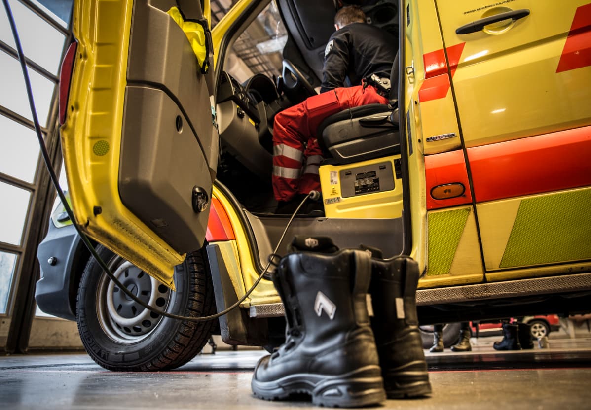 Kengät pelastuslaitoksen lattialla ambulanssin vieressä