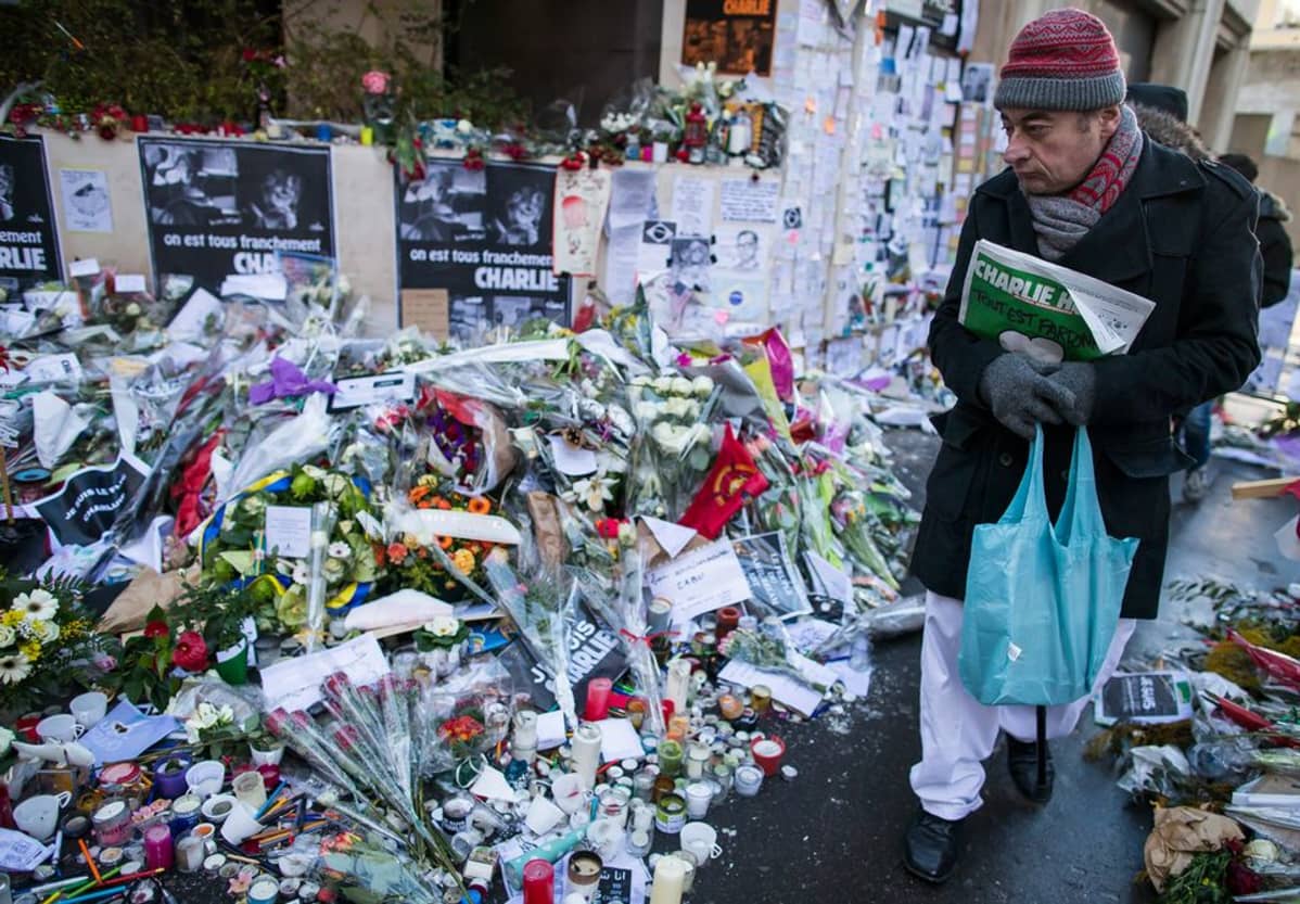 Mies kävelee pidelleen Charlie Hebdo -lehteä käsissään