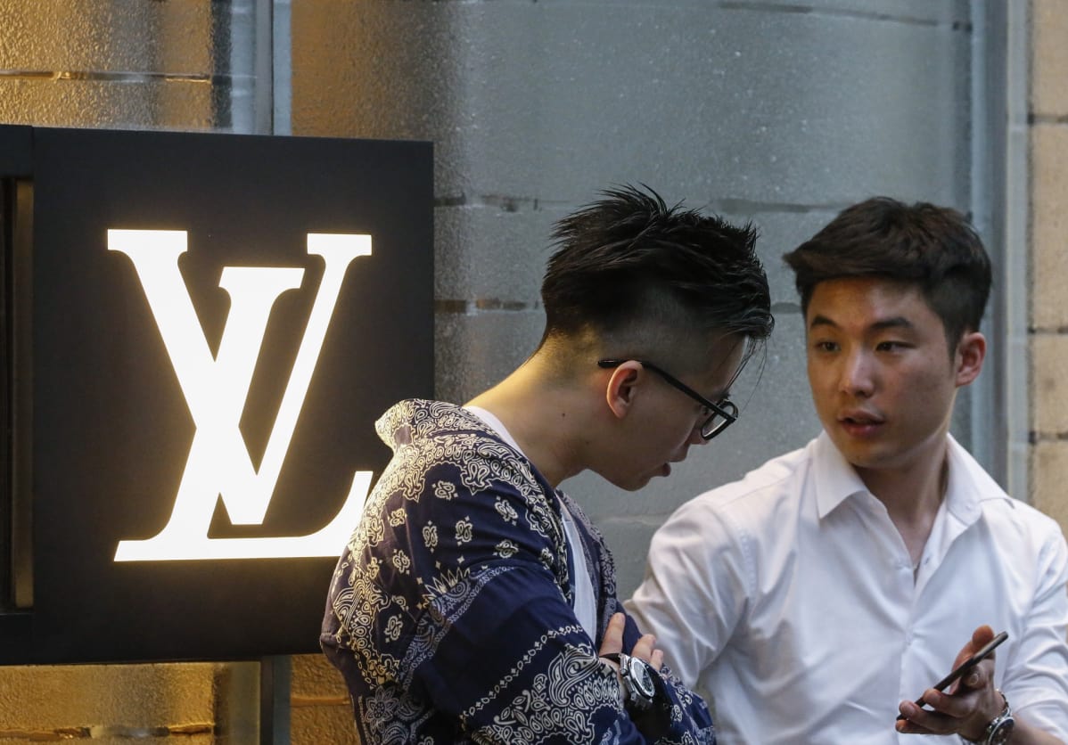 Miehiä muotialan yritys Louis Vuittonin liikkeen edustalla SIngaporessa.