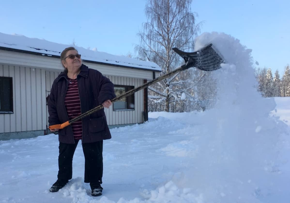 Eeva Korhonen pitää pihan omin käsin puhtaana.
