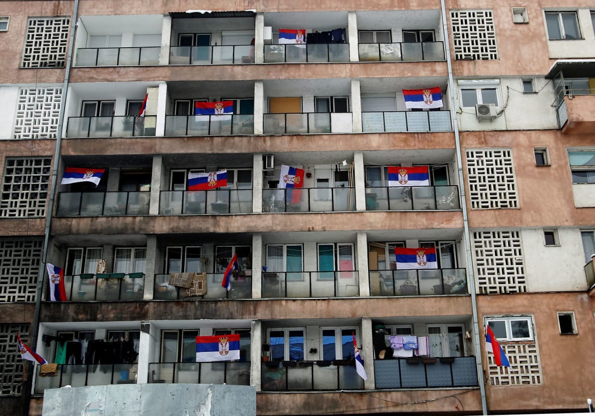 kerrostalo ja lippuja parvekkailla