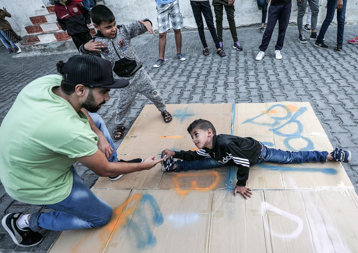 Palestiinalainen tanssija Ahmed Al-Ghariz kouluttaa nuoria ja lapsia tanssimaan al-Nusairatin pakolaisleirillä Gazan alueella 5. marraskuuta.