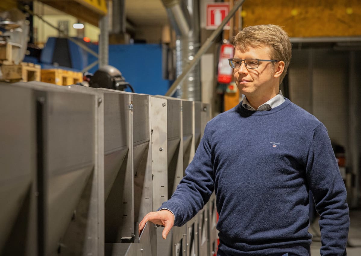 Teuvan Keitintehtaan toimitusjohtaja Henri Penttilä seisoo tehtaalla kiuaskomponenttien vieressä.