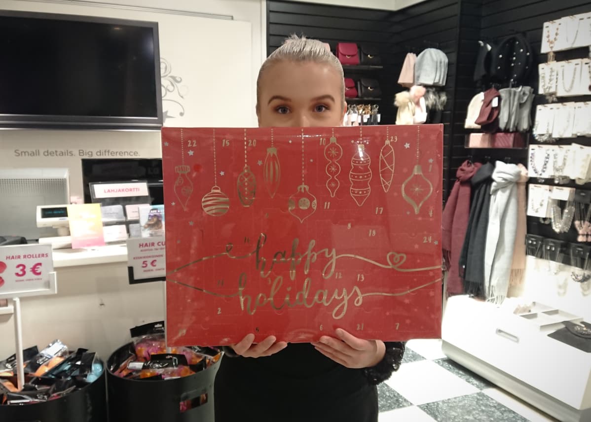 Heidi Malinen pitelee käsissään joulukalenteria Glitterin Joensuun myymälässä.