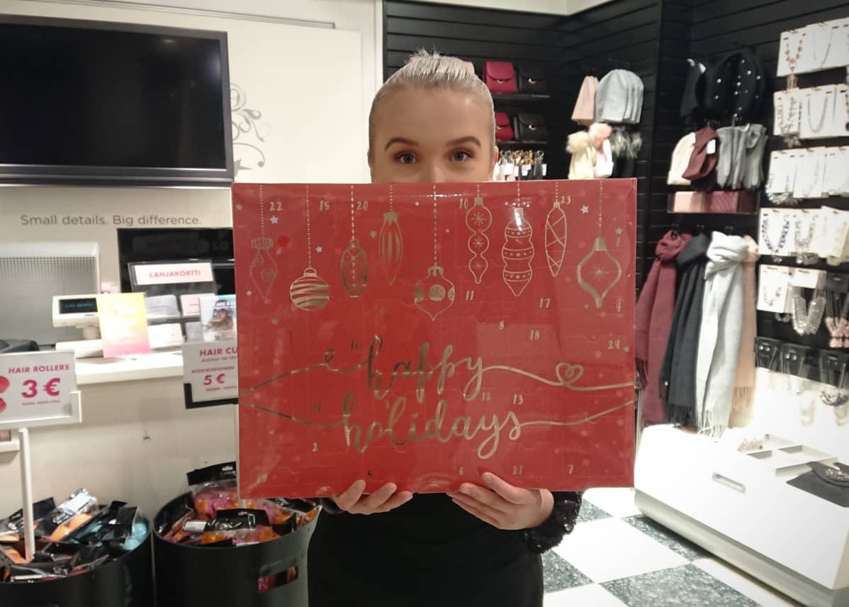 Heidi Malinen pitelee käsissään joulukalenteria Glitterin Joensuun myymälässä.
