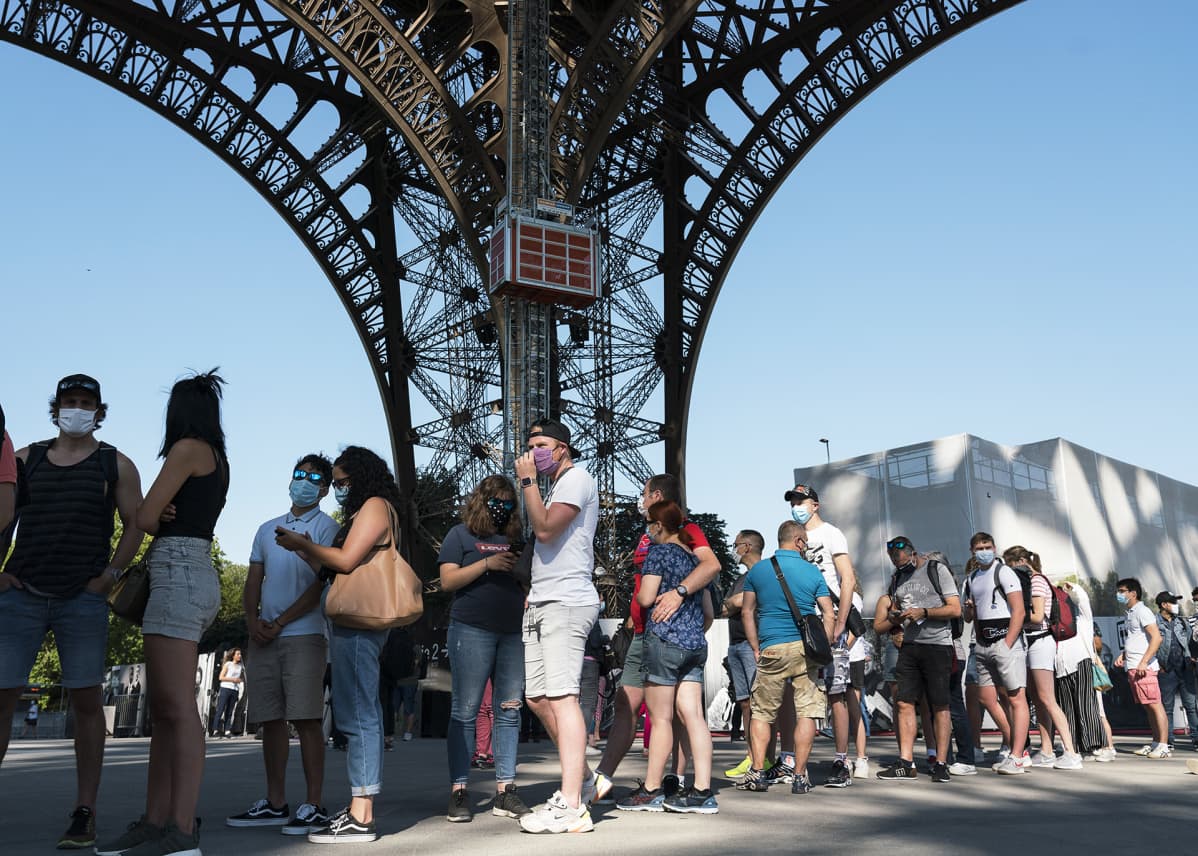 Ihmiset jonottivat Eiffel-torniin pääsyä.