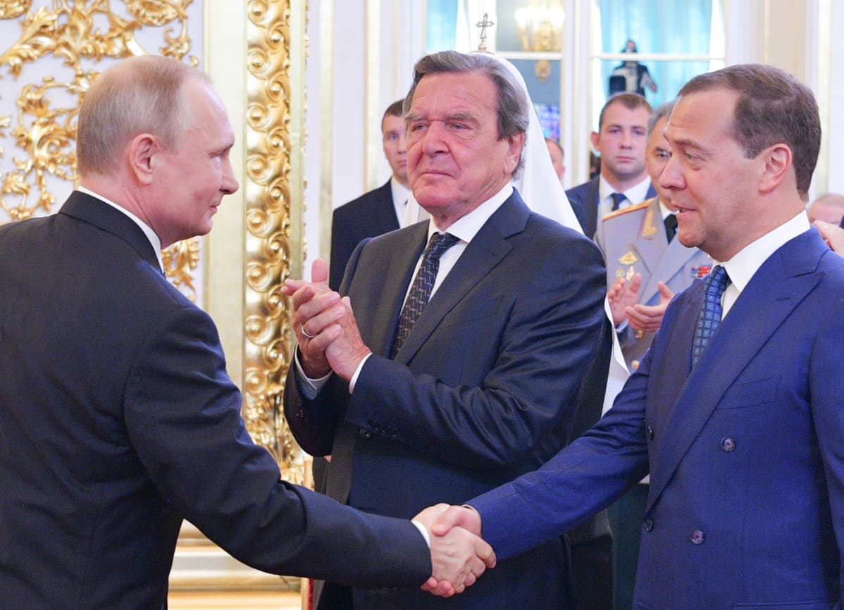 Vladimir Putin kättelee Dmitri Medvedeviä.