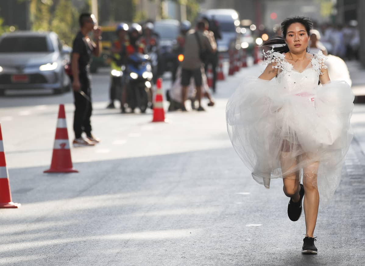 Thaimaalainen morsian kilpailee ”Running the Brides” -tapahtumassa Bangkokissa, Thaimaassa, 24. marraskuuta. Sataviisikymmentä morsiusparia kilpailivat kolmen kilometrin juoksukilpailussa jahaastetehtävissä tarkoituksena oli voittaa hääpakettipalkinto Malediiveille.