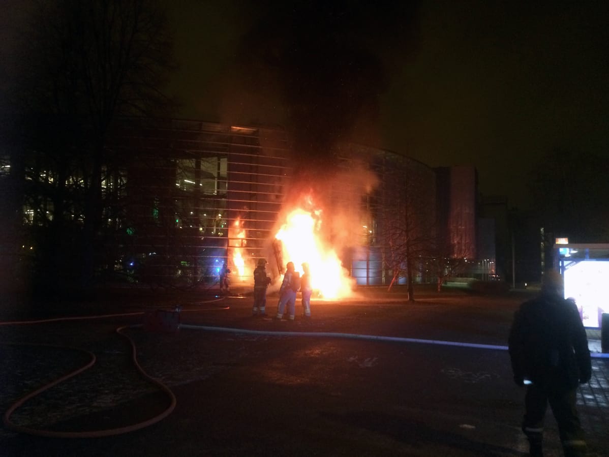 Palomiehiö palavan taideteoksen edessä Helsingin Viikissä.